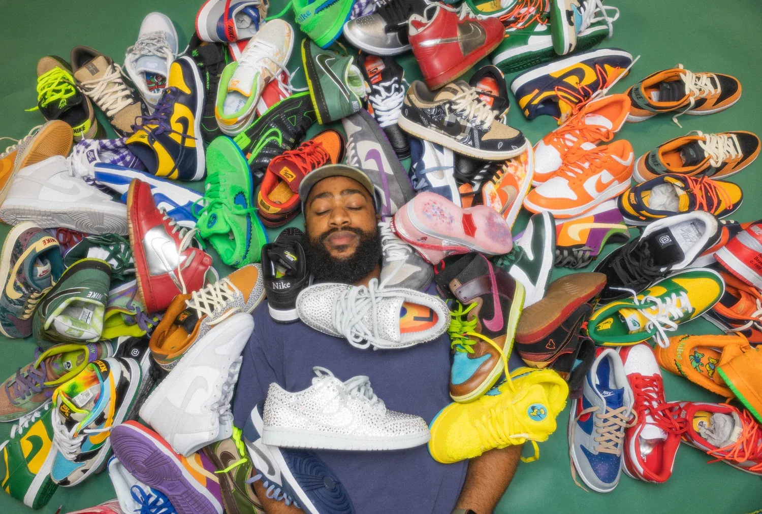 Kelechi lying in a pile of colorful sneakers